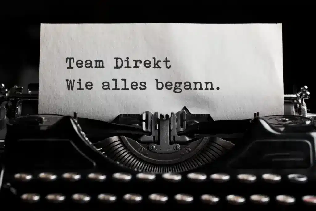 Alte Schreibmaschine mit eingespanntem Blatt: Team Direkt - wie alles begann, Bodenschutz und Staubschutz seit 1996